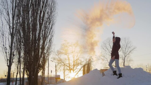 Woman in burgundy jacket throwing hot water from mug in cold air at low temperature, warm water turning to steam - Mpemba effect, slow motion. Experiment, science, winter outdoor leisure time concept