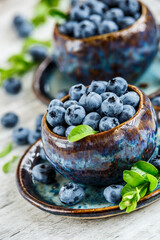 Fresh blueberries background with copy space for your text.Blueberries in a bowl on a wooden table....