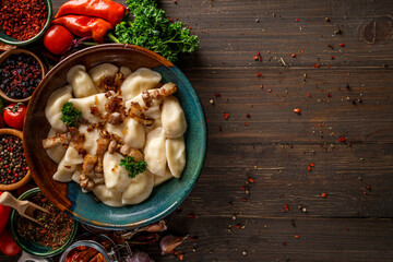 Pierogi or pyrohy, varenyky, vareniki, dumplings served with caramelized salted onion in bowl on...