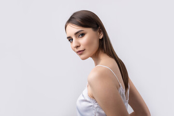 Beautiful smiling woman with clean skin, natural make-up and white teeth on a gray background