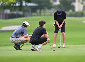 Young boys playing golf in a competitive tournament