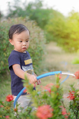 Asian Toddler Boy watering his homegrown flower