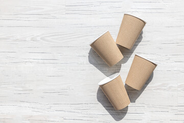 Recyclable cardboard paper cups on a white wooden background	