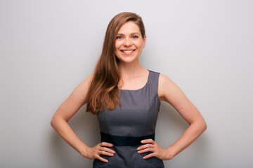 Smiling business woman in gray dress with hands on waist. isolated female business person portrait. Whide toothy smile.