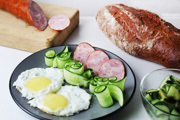 zastrak eggs scrambled eggs sausage salad cucumbers on the trael view from the side top. Traditional English American breakfast. First meal. The benefits of proper nutrition Egg Day. Egg dishes