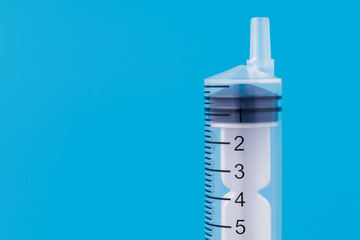 Classic disposable syringe without a needle on a blue medical background with copy space