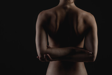 Naklejka premium girl's back close-up on a dark background, the concept of treatment of the spine and back