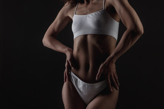 body shape of a sporty fitness girl studio photo on a dark background, the concept of sports and healthy eating