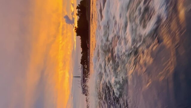 view from the boat to the pink sky over the Neva River near the island at dusk, bridges and a skyscraper in the background