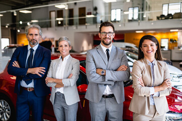 Team of happy salespeople are working together at car dealership. - 517568881