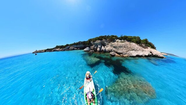 Aerial view kayak in the cliffs and cave of Petit Sperone beach, close to the Bonifacio town in Corsica of France. Drone view of people kayaking in the Mediterranean sea by Piana island.