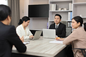 Collaborative process of professional businesspeople going over on new project together, using computer presentation and brainstorming ideas, coworker and working together at office meeting concept