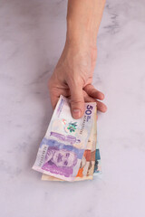 Man's hands counting money from Colombia