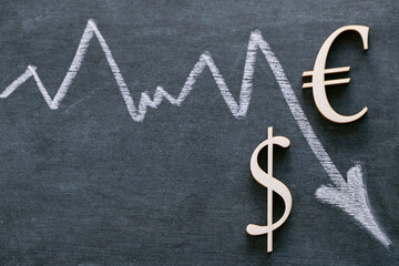 Falling euro currency rate.Dollar and Euro sign and a white down arrow on a black background. Financial Crisis.Exchange rate and Euro dollar Price increase. 