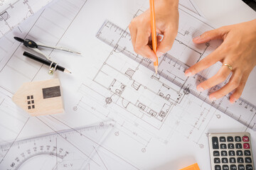 Architectural project workspace. Top view of architect drawing with ruler on house plan blueprint paper for repair tools on table desk at architecture office, architect sketching construction project