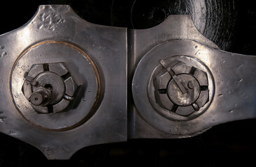 Macro detail of coupling rods on steam locomotive showing fastening nuts, cotter pins, key locks, and tool marks