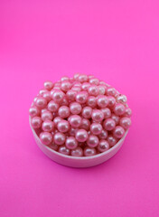 Pink pearl beads on pink background