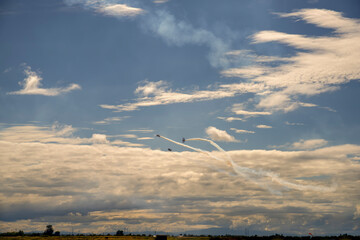 three aircraft show aerobatics in the sky above the field