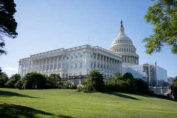 The U.S. Capitol, a domed classical building housing the U.S. Senate and House of Representatives, with its West Front covered in scaffolding for maintenance.