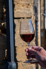 Tasting of red wine by old wine maker in Pierres Dorées region with yellow stone houses on south of Beaujolais region, France