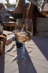 Dinner at sunset in French restaurant with cold dry rose wine in Port Grimaud, summer vacation on French Riviera, France