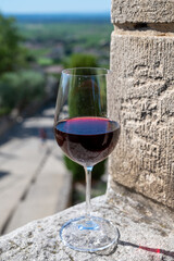 Glass of red dry wine and ruins of medieval castle of Châteauneuf-du-Pape ancient wine making village in France