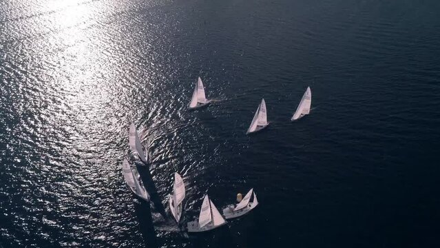Beautiful aerial view of yachts, unfolding around the float on the river in the sun rays. yachts are racing over the waves.