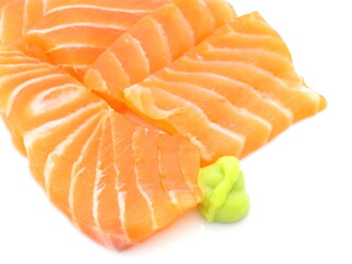 Pieces of fresh salmon slice and wasabi on white background