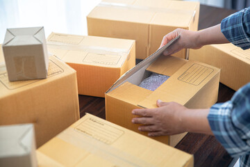 Closeup view of female packing package shipping box