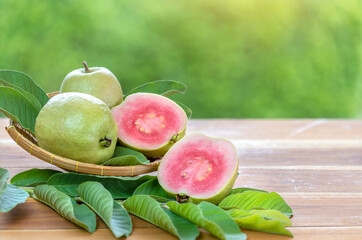 Sweet Red Guava fruit with leaf on blur garden background, Fresh Pink Guava fruit on wooden basket...