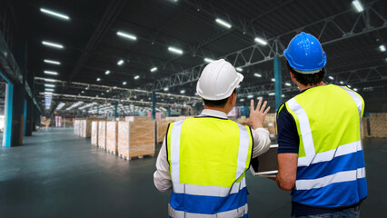 Fototapeta na wymiar Rear view group of worker standing and checking large retail warehouse logistics, distribution center with computer. Multiethnic business manager looking in future with warehouse building.