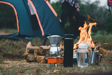 Manual equipment coffee set with bonfire in camping of people camper group in nature near the...