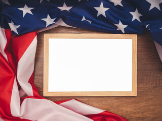 Top view of the American flag and empty mini whiteboard over a wooden table