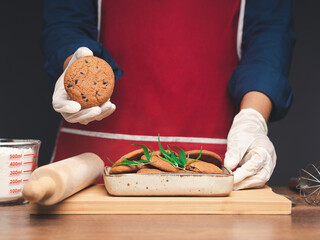 A chef holding cannabis chocolate chip cookies while standing in the kitchen