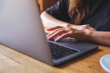 Closeup image of a woman working and touching on laptop computer touchpad