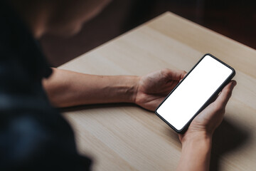 Man holding a white blank mobile phone on the desk in the office