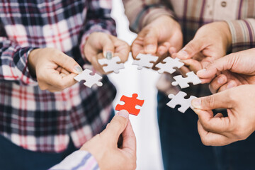 The concept of cooperation. A group of business people assembling jigsaw puzzle. teamwork, help and...