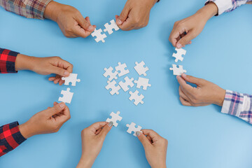 The concept of cooperation. A group of business people assembling jigsaw puzzle. teamwork, help and support in business.
