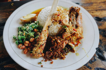 Nasi Campur Ayam Betutu. Balinese roast chicken stuffed with cassava leaves. Accompanied with...