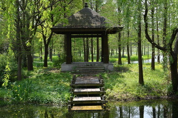 a traditional Chinese style pavilion in the woods by the small river