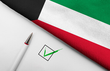 Pencil, Flag of Kuwait and check mark on paper sheet
