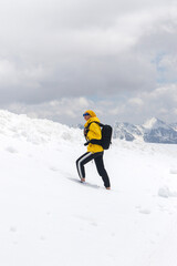 Adult woman with a backpack tourist on a mountain peak in winter. Travel and active lifestyle concept.