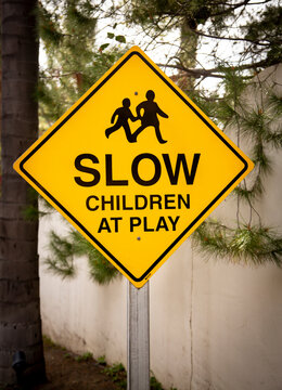 Yellow traffic sign with graphic stating Slow Children at Play