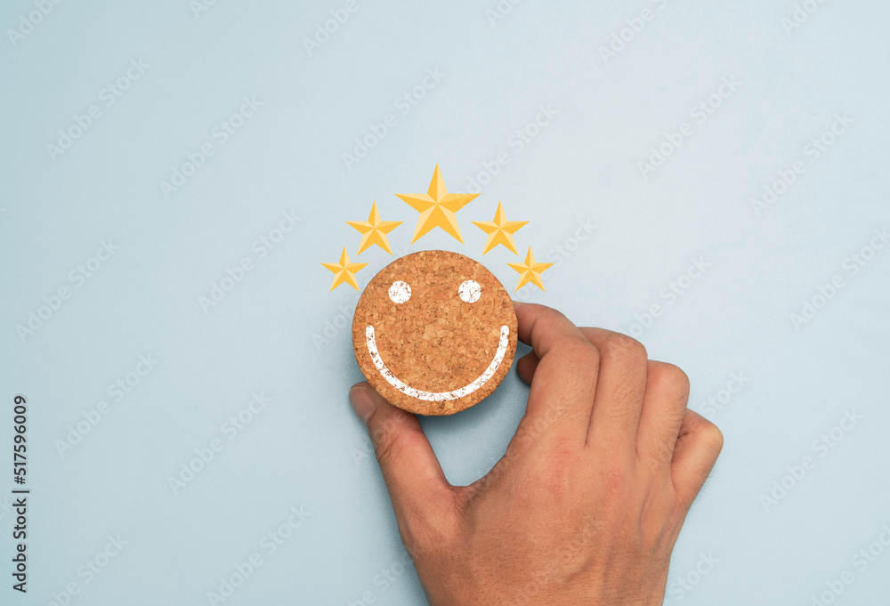 Poster hand holding round wooden block which print screen smile face with yellow five stars for client exce