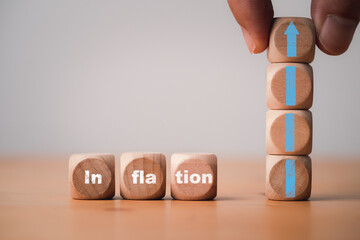 Inflation wording print screen on wooden cube block with hand holding up arrow for economic...