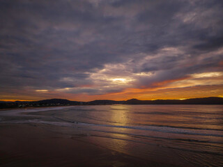 Fototapeta na wymiar Cloud filled winter sunrise sky at the beach