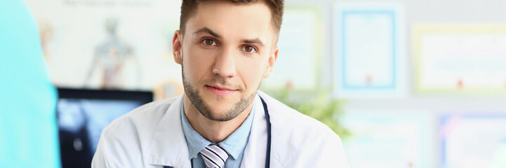 Fototapeta premium Attractive young medical worker in white uniform, wait patient for planned appointment