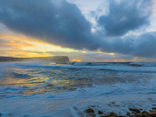 Obraz premium Sunrise at the seaside with large and powerful sets