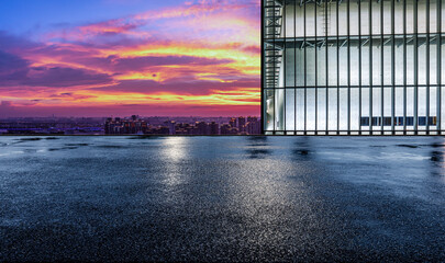 Asphalt road platform and city skyline with sky cloud scenery at sunset