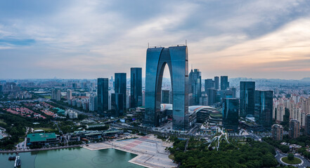Naklejka premium Aerial view of city skyline and modern commercial buildings in Suzhou at dusk, China.